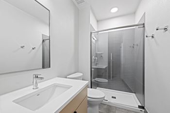 A modern bathroom with a white sink and a walk-in shower at The Avenue Lofts Golden Apartments, Golden